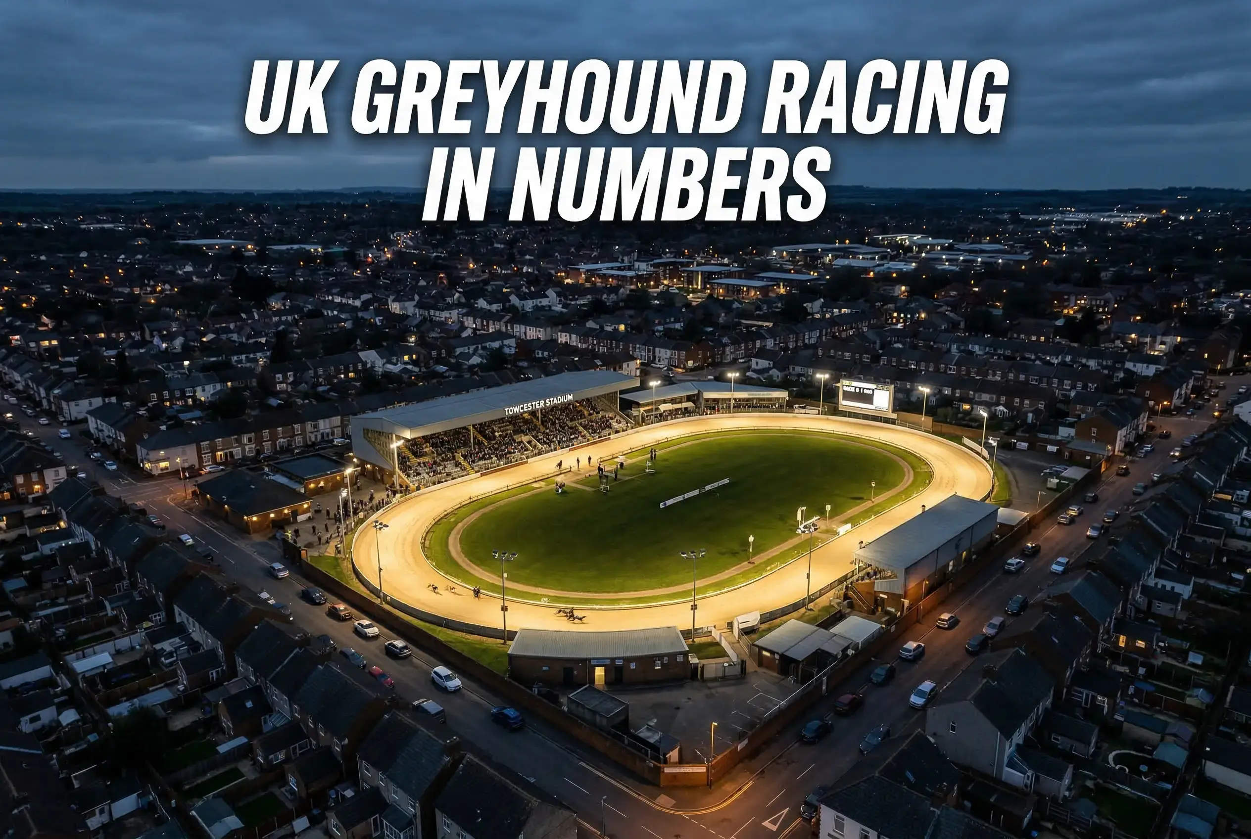 Aerial view of a British greyhound racing stadium with floodlights and surrounding urban area